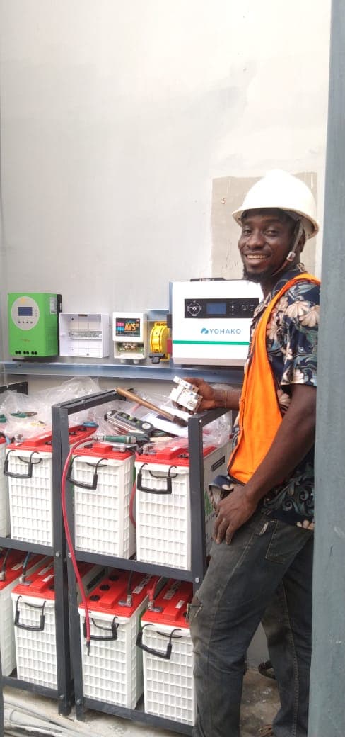 Diverse team of solar installers smiling on a job site.